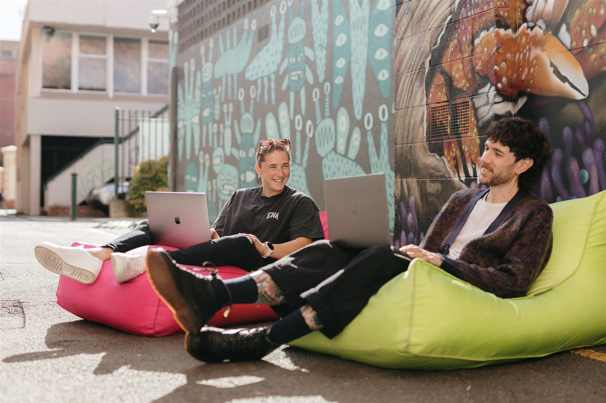 People working on laptops in a laneway